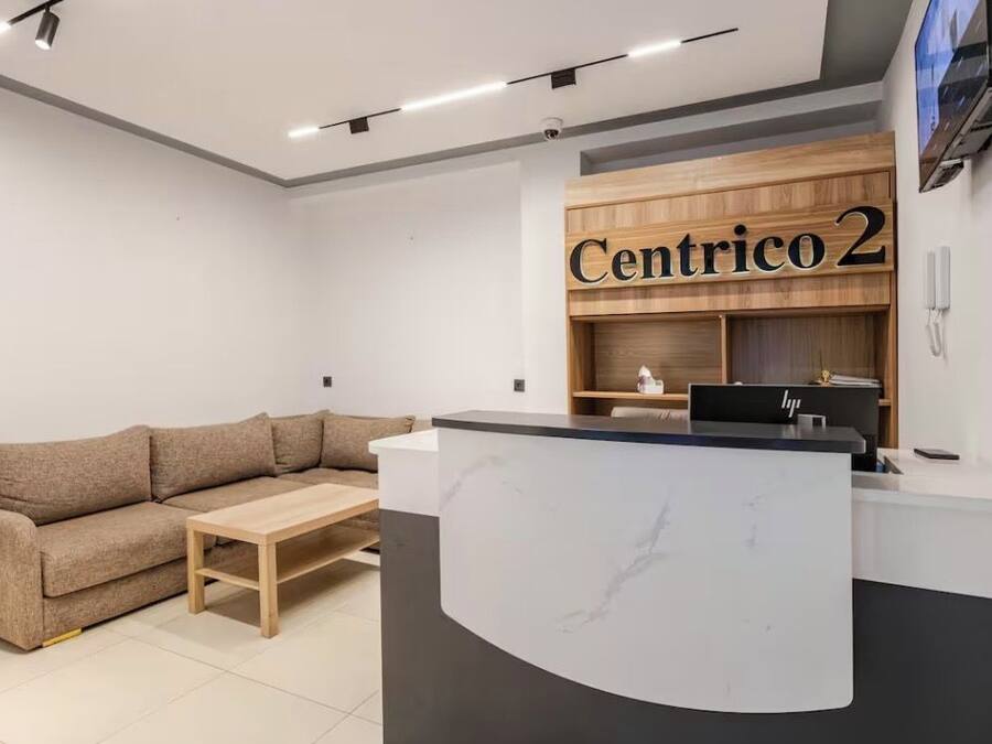 A reception area with a wooden desk, a sofa, and a coffee table.