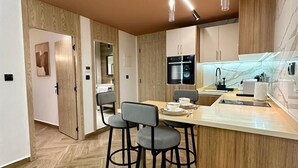 Une cuisine moderne avec des meubles en bois, un îlot central doté de tabourets et des appareils électroménagers intégrés.