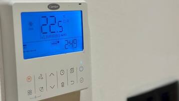Een Carrier-thermostaat met een digitaal scherm dat 22,5°C aangeeft en een tijd van 2:49 toont.