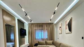 Un salon moderne avec un canapé, une table basse et un téléviseur.