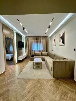 Apartamento luxo, 2 quartos | Área de estar | Smart TV 50 polegadas com canais via satélite, lareira, Netflix