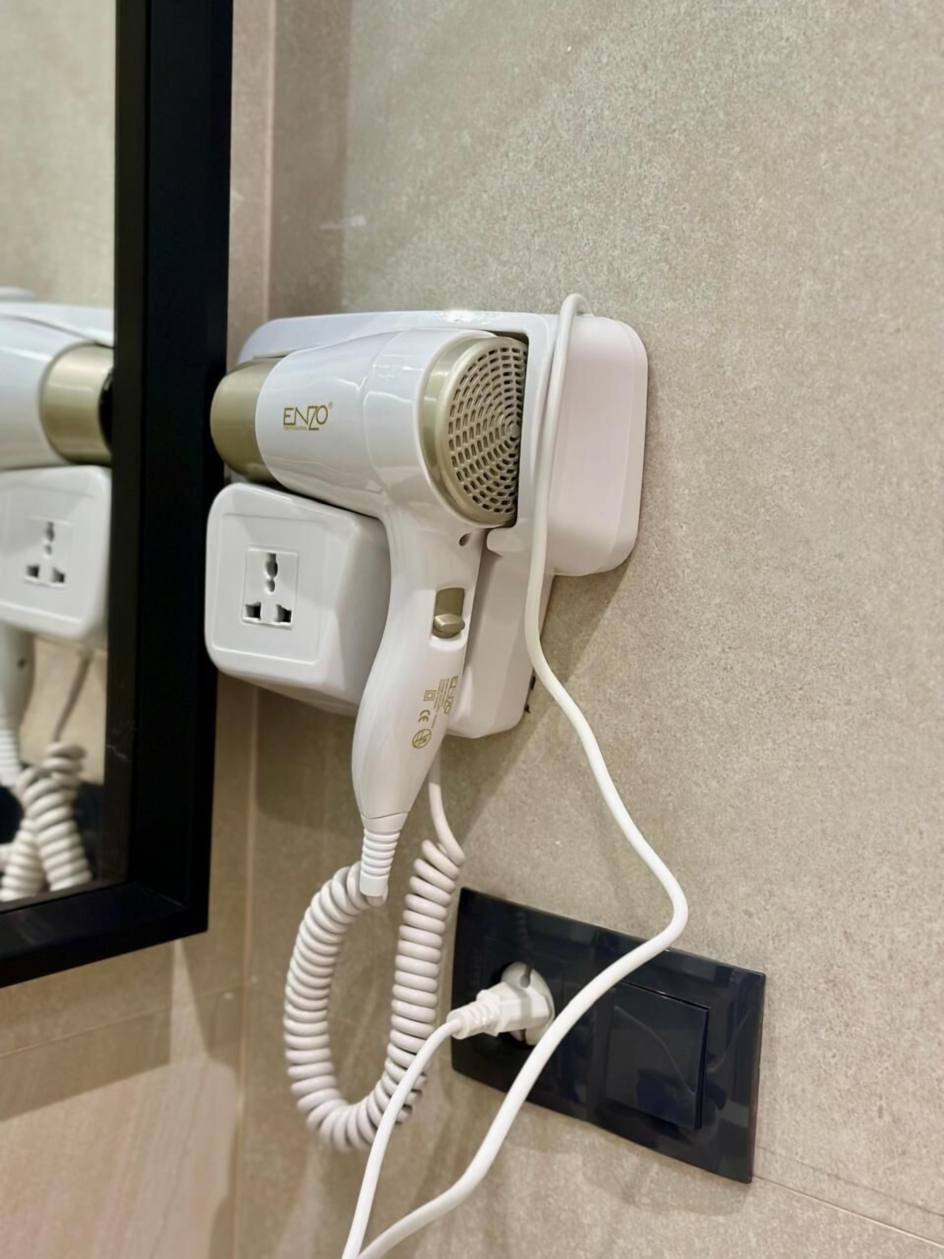 Un sèche-cheveux branché sur une prise de courant dans une salle de bain.