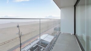 Ein Balkon mit freiem Blick auf Strand und Straße.