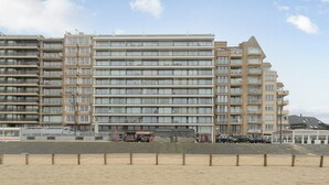 Ein mehrgeschossiges Hotel mit modernem architektonischen Design, mit Balkonen und großen Fenstern.