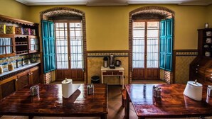A traditional kitchen with wooden cabinets, a coffee machine, and a tiled backsplash. - Hostel Covent Garden by gaiarooms  (León)