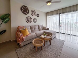 Ein modernes Wohnzimmer mit grauem Sofa, einem Couchtisch und dekorativer Wandkunst.