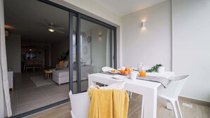 Een eetgedeelte met een tafel gedekt voor twee personen, een schuifdeur naar een woonruimte en een plafondventilator.