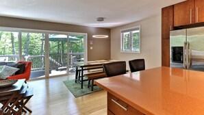 A modern kitchen with a large island, wooden cabinets, and a built-in refrigerator.