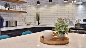 A modern kitchen with white subway tiles, a wooden countertop, a built-in oven, and pendant lighting. - Renovated. Mountain Views. Steps to Killington. Discounted Ski Rentals. 3C16 (Killington)