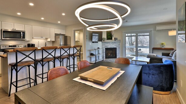 A modern kitchen with white cabinets, a built-in microwave, and a stainless steel refrigerator.
