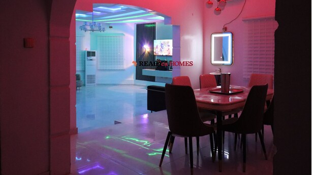 Un intérieur moderne comprenant un coin repas, un téléviseur et un miroir.