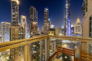 A high-rise building with a glass balcony overlooking a cityscape at night. - FIRST CLASS | 2BR | Burj Khalifa & Fountain View (Dubai)