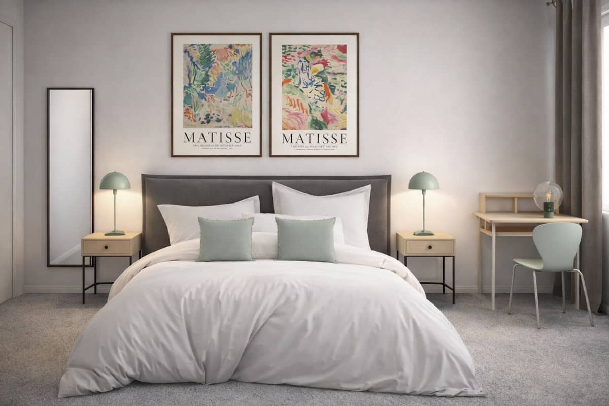Un dormitorio moderno con una cama grande, dos mesitas de noche con lámparas, un escritorio con silla, y dos obras de arte enmarcadas en la pared.