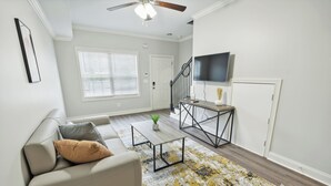 A living room with a sofa, coffee table, and a patterned rug.