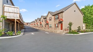 A row of modern, multi-story buildings with a uniform architectural style, featuring brick facades and red-tiled roofs.