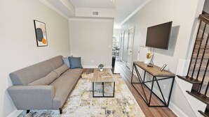 Una sala de estar con sofá, mesa de centro y televisor.