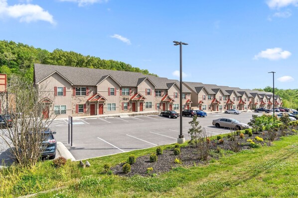 A row of single-story buildings with a parking lot in front.