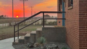 Un edifici de maó amb una escala de formigó que condueix a una porta.