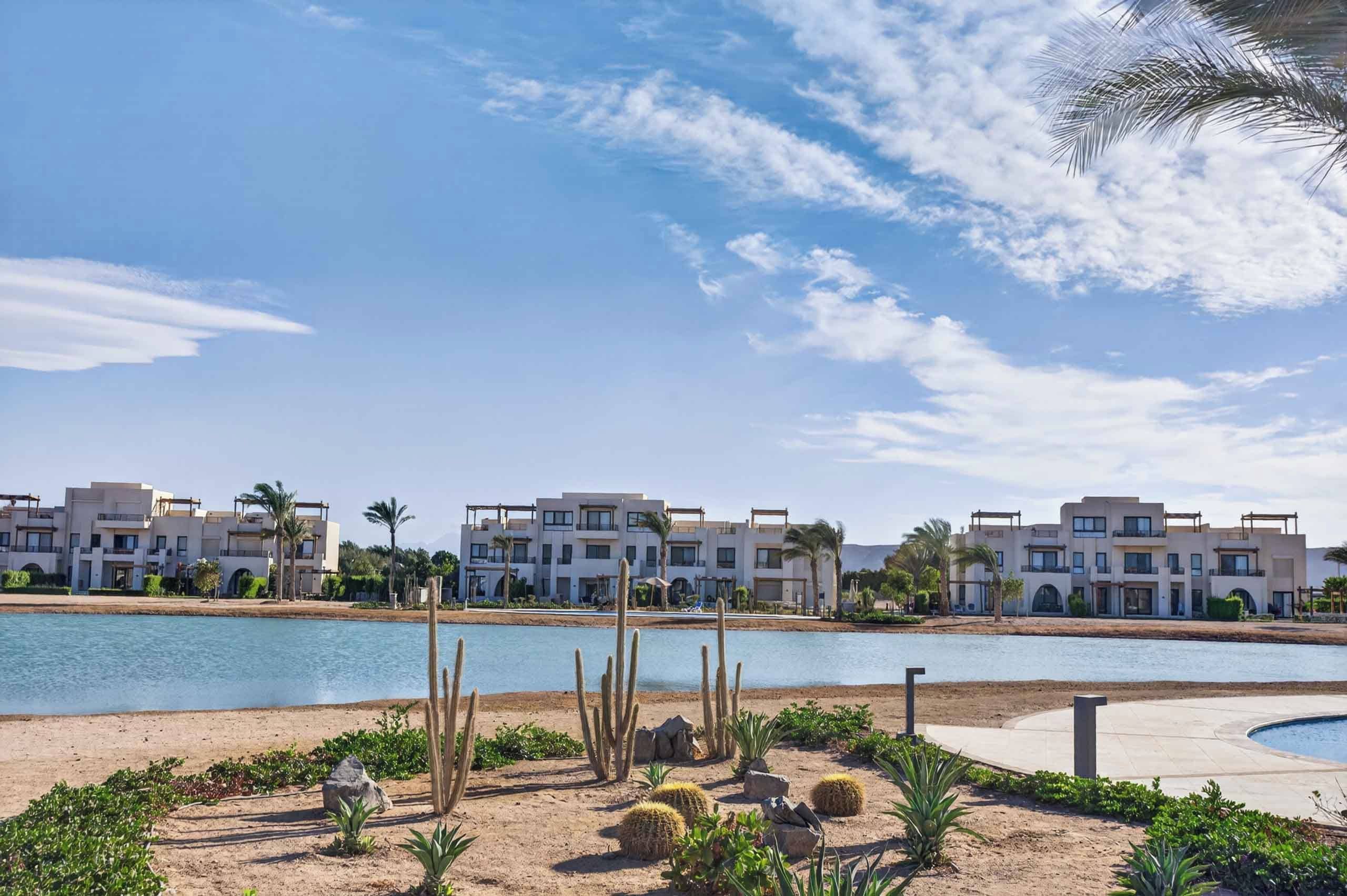 Ein Resort mit mehrstöckigen Gebäuden, einem Pool und Wüstenlandschaft.