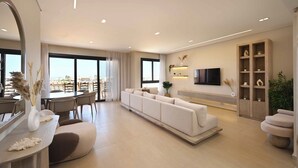A modern living room with a sofa, a dining area, and a TV mounted on the wall. - El Gouna - BIRD NEST (El Gouna)