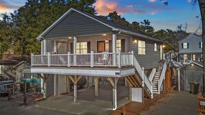 A two-story house with a balcony, a garage, and a driveway.