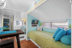 Cozy space with bunk bed, TV, and dining area.