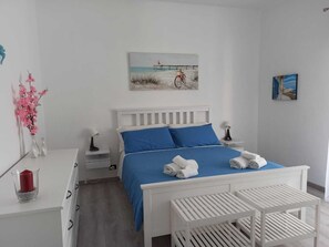 Relax in a serene bedroom with a comfortable bed, a nightstand, and a beautiful painting above.