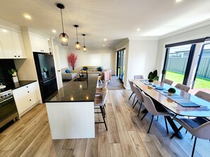 A modern kitchen with a central island, built-in appliances, and pendant lighting.