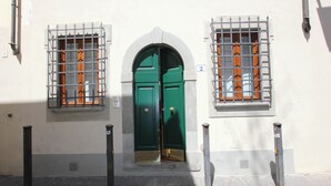 A building with a green door and two windows with barred glass. - Marsili Suite (Florence)