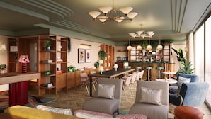 A spacious living room with a wooden bookshelf, a dining area, and a bar with stools. - The July London Victoria (London)