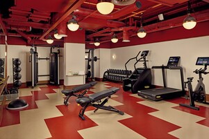 Ein Fitnessstudio mit Trainingsgeräten, Laufbändern und Kurzhanteln.