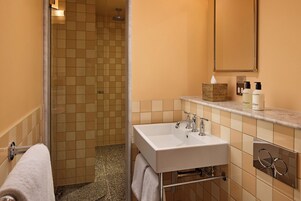 A bathroom with a shower, a sink, and a mirror.