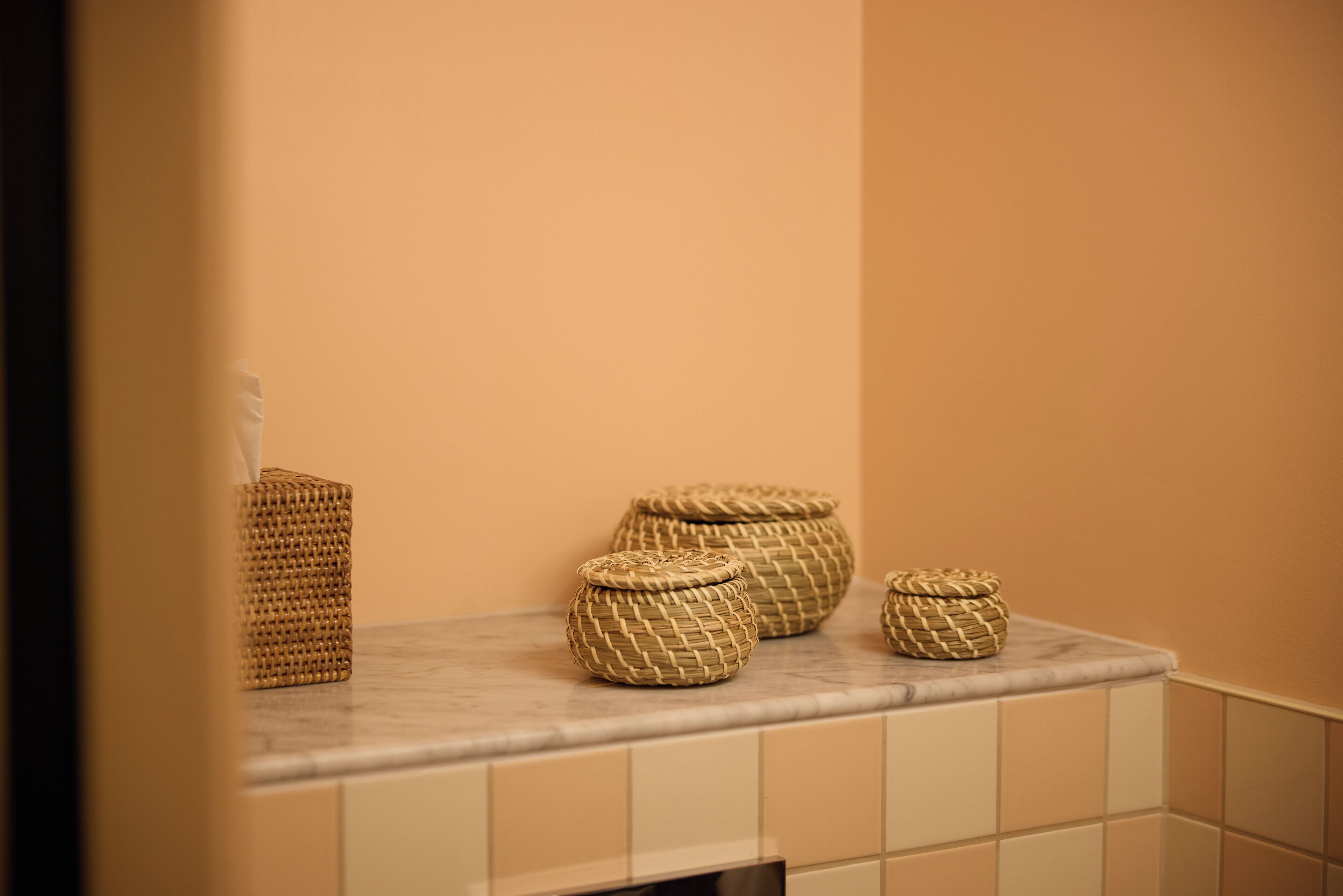 Wicker baskets on a bathroom countertop.