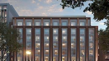 Moderni rakennus, jossa on tiiliverhous, suuret ikkunat ja kaarevat sisäänkäynnit.