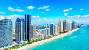 A coastal cityscape with high-rise buildings, a beach, and clear blue skies. - Modern 2-bedroom Retreat Near Beach Airport (Fort Lauderdale)