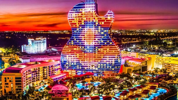 A hotel with a guitar-shaped facade, multiple swimming pools, and a waterfront location. - Modern 2-bedroom Retreat Near Beach Airport (Fort Lauderdale)