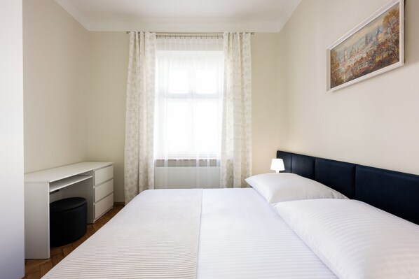 Un dormitorio con cama, escritorio y silla.
