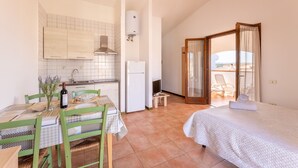 Una habitación compacta con cocina, comedor y cama.
