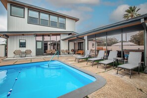 A modern house with a swimming pool, outdoor seating, and large windows. - Luxury on Ocean Drive - Sleeps 28 (Corpus Christi)