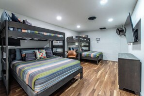 A bunk bed room with a desk, chair, and a TV mounted on the wall. - Luxury on Ocean Drive - Sleeps 28 (Corpus Christi)