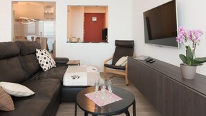 Een moderne woonkamer met een bank, fauteuil en een salontafel met glazen.