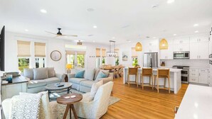 A spacious living area with a sofa set, a coffee table, and a dining area with chairs and a table.