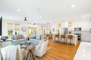 A spacious living area with a sofa set, a coffee table, and a dining area with chairs and a table.