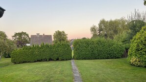 A well-maintained lawn with a stone pathway leading to a house. - Vacation home Friesenkoje, in Loquard near Greetsiel and Emden, dogs allowed (Krummhörn)