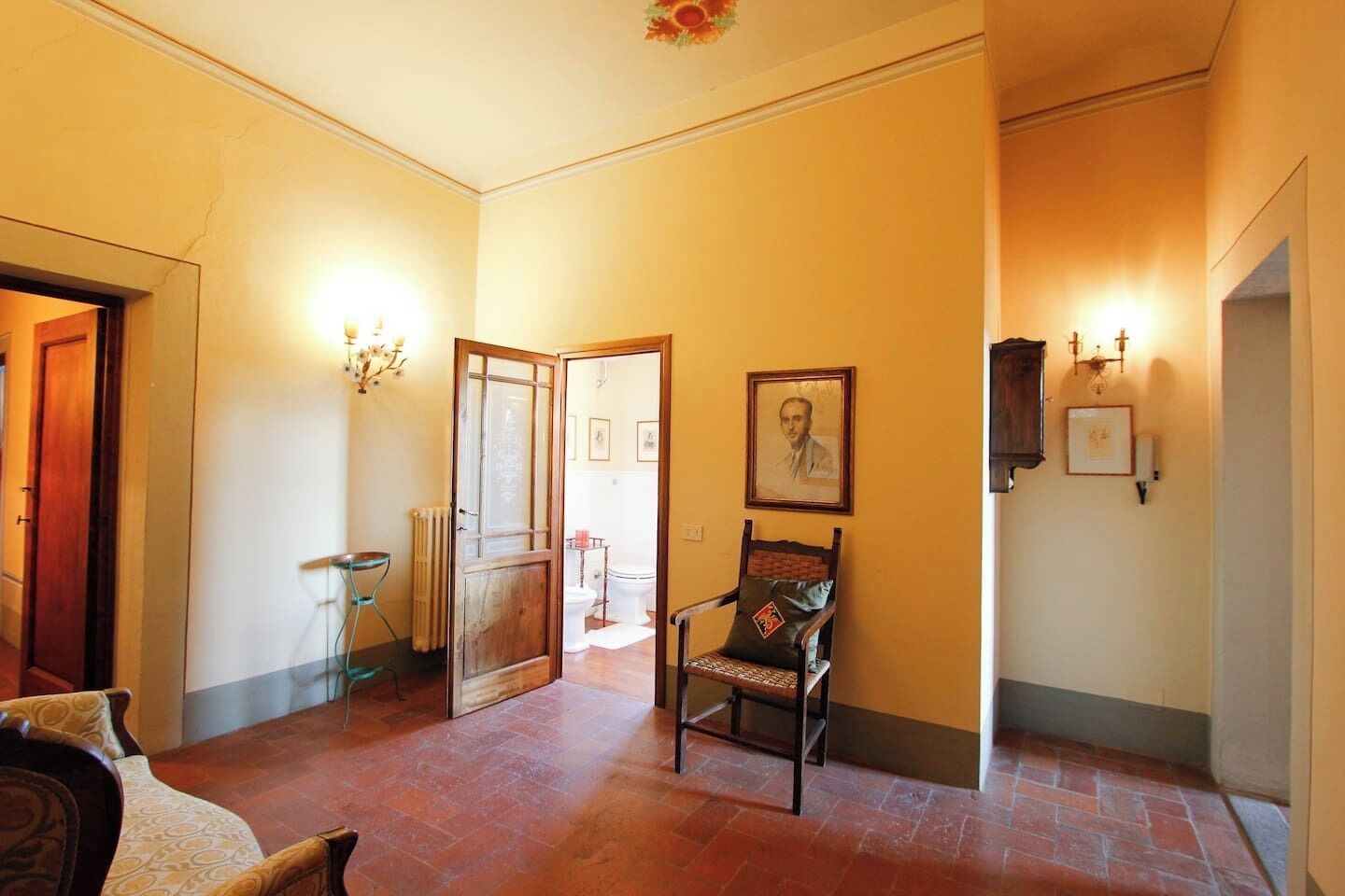 A hallway with a wooden door, a chair, and a radiator.