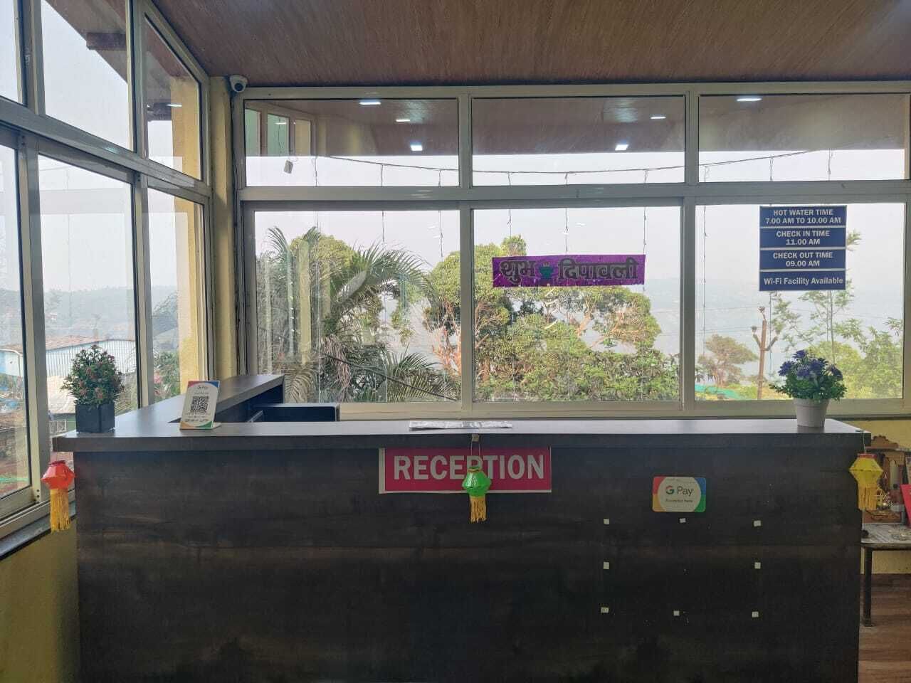 A reception desk with a sign indicating hot water time and check-in/check-out times.