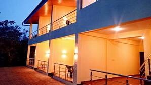A modern two-story building with multiple balconies and a staircase. - Heaven Hills Resort (Mahabaleshwar)