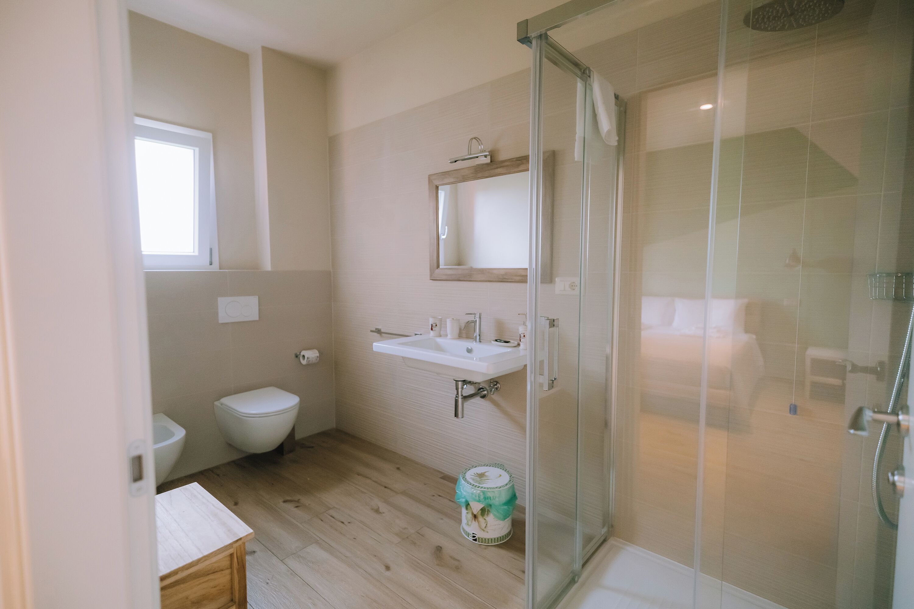 A bathroom with a toilet, sink, and shower area.