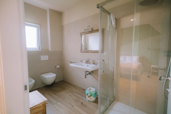 A bathroom with a toilet, sink, and shower area.