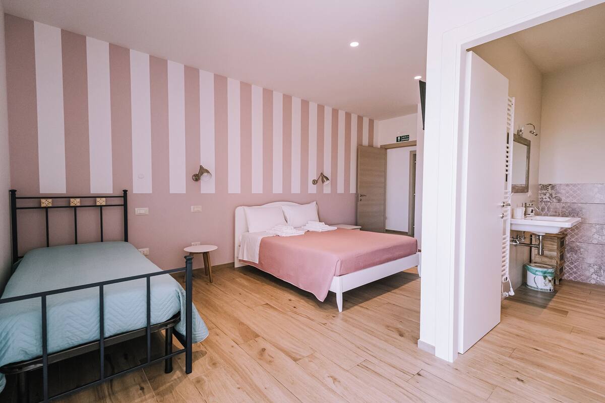 A bedroom with a bed, bedside table, and a small round table.